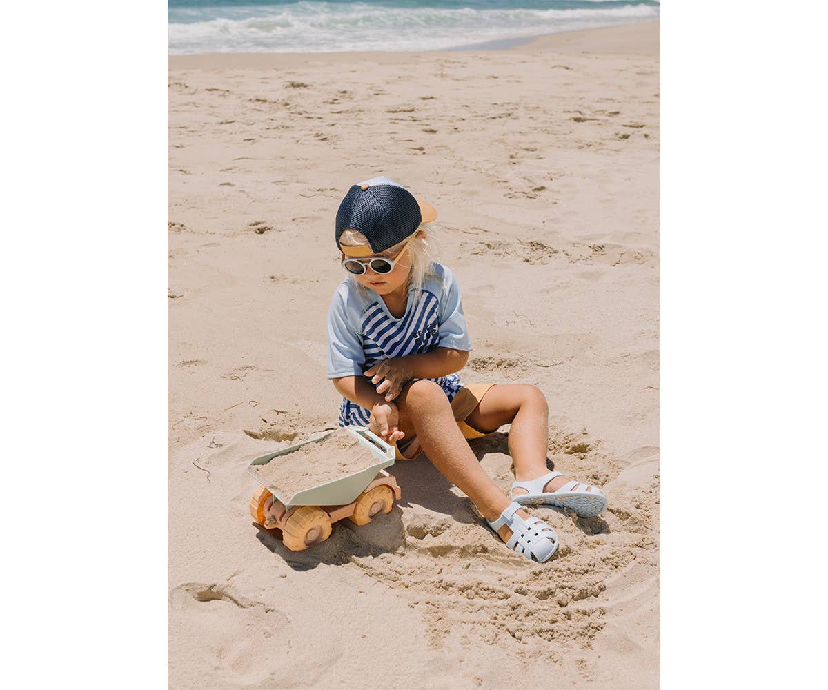 Camion Benne Sand Monnëka avec benne basculante et roues mobiles pour enfants dès 6 mois, idéal pour jouer dans le sable et à la plage.